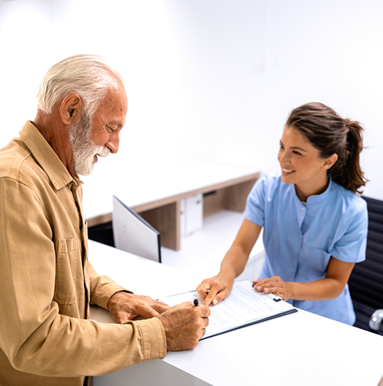 Senior man signing dental paperwork