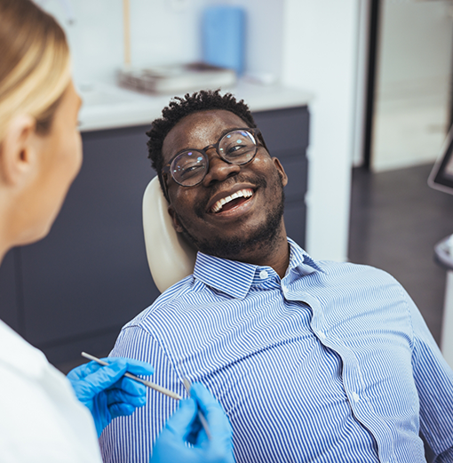 Man in the dental chair smiling at his dentist
