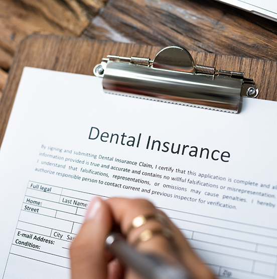 Person filling out dental insurance paperwork