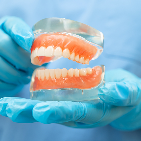 Dentist holding a model of dentures