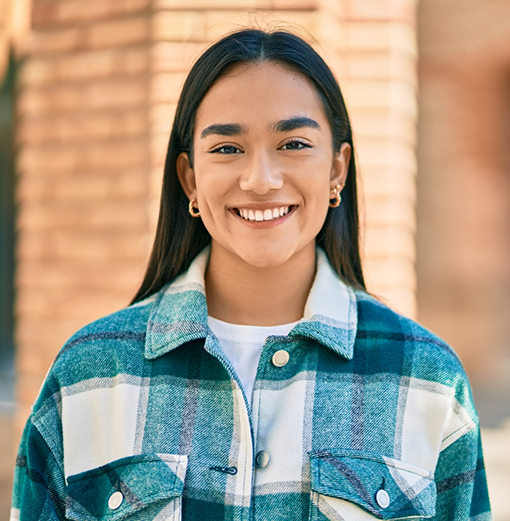 Young woman with long dark hair smiling after restorative dentistry treatment