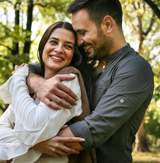 Man and woman hugging outdoors after cosmetic dentistry in Norwood