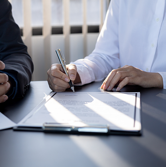 Two people at a desk filling out forms