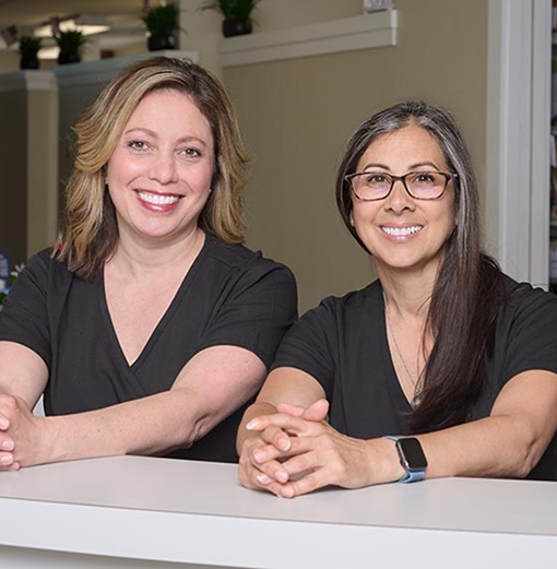 Two smiling Norwood Dental Care team members
