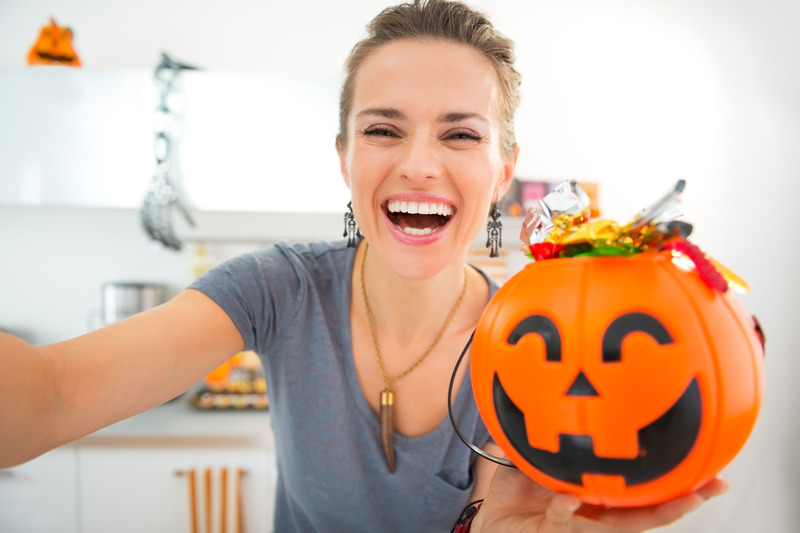 Patient holding Halloween candy while wearing ClearCorrect